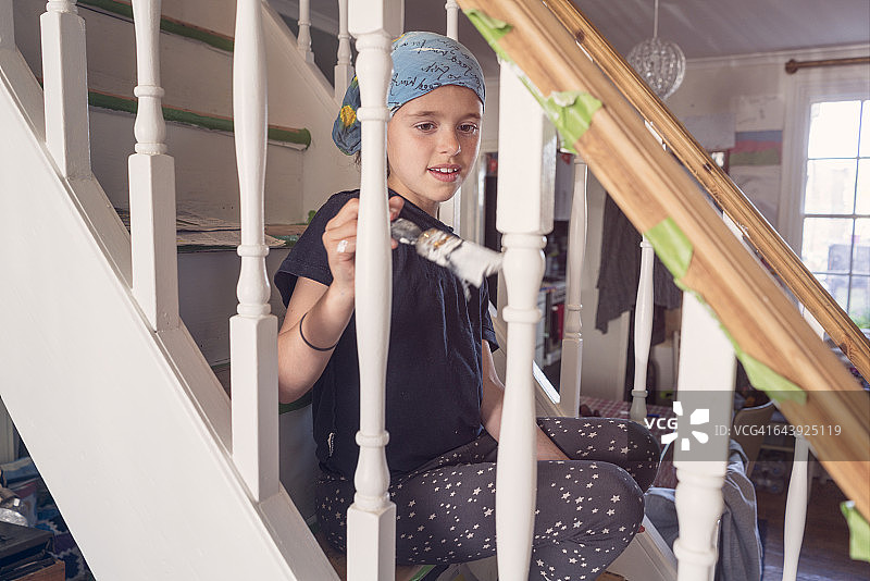 小女孩粉刷栏杆图片素材