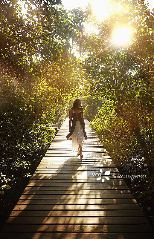 丛林木栈道上的太平洋岛屿妇女图片素材