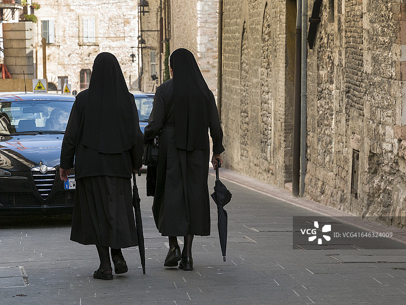 修女撑伞逆行图片素材