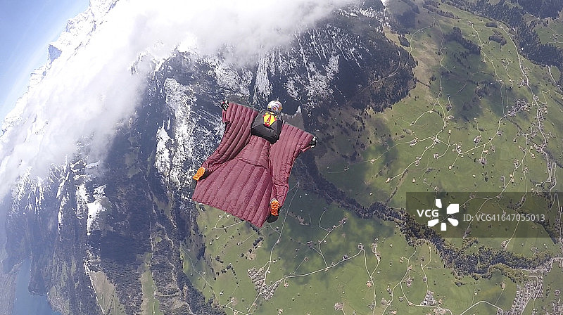 翼装飞行员在空中飞越群山图片素材