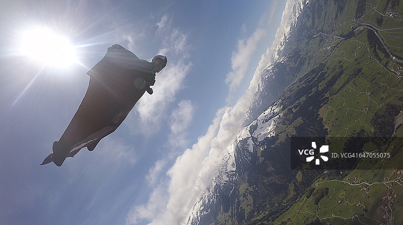 翼装飞行员在空中飞越群山图片素材