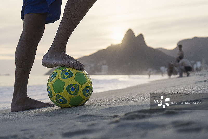 巴西里约热内卢伊帕内玛海滩，男子持球站立图片素材