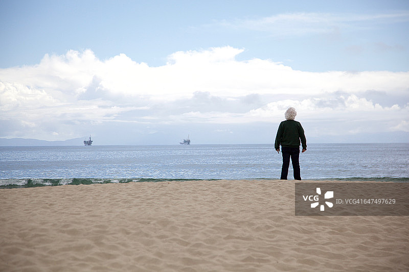 年长的女人站着看海图片素材