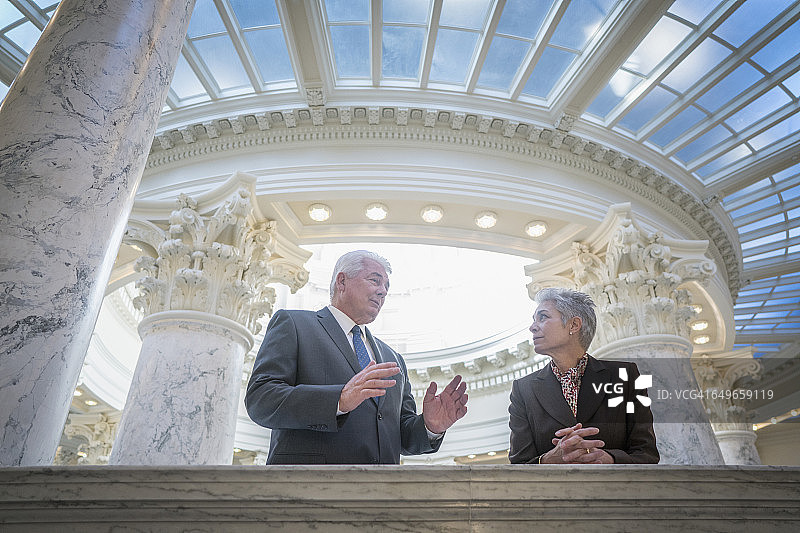 在国会大厦交谈的白人参议员图片素材