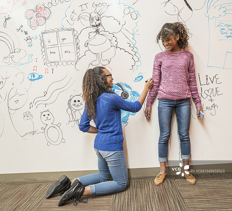 女孩在白板上描绘朋友图片素材