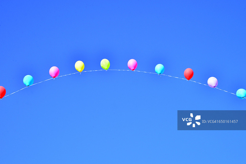 蓝天下用绳子串起来的彩色气球图片素材