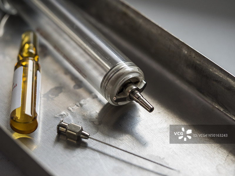 医疗托盘上的复古玻璃注射器特写图片素材