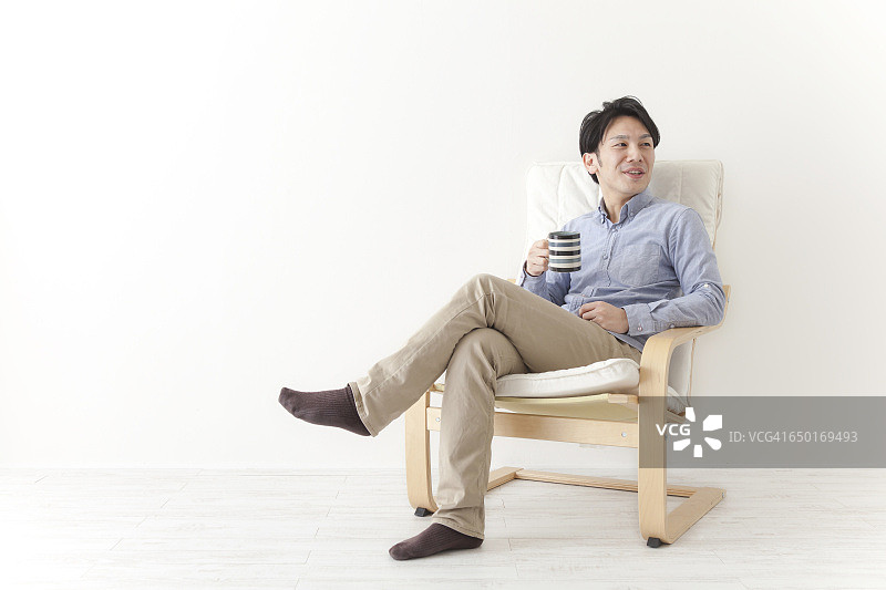 坐在椅子上放松的日本男人图片素材