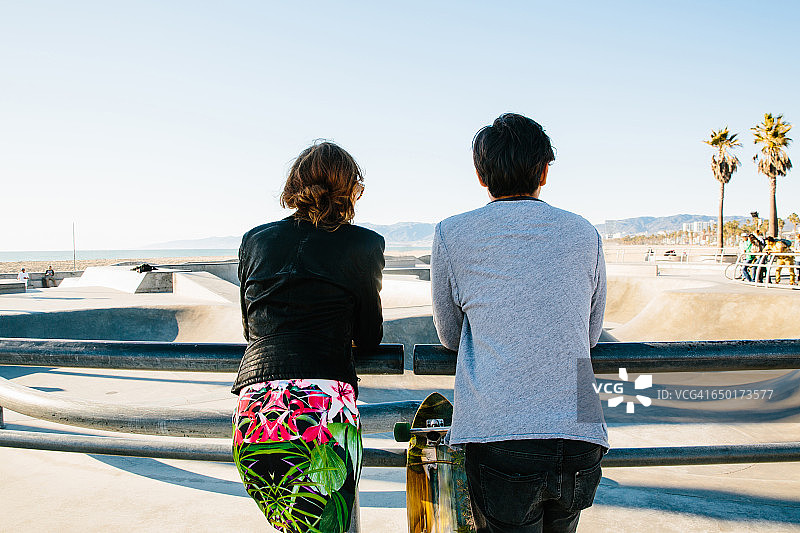 依偎在栏杆旁的年轻夫妇（背影）图片素材