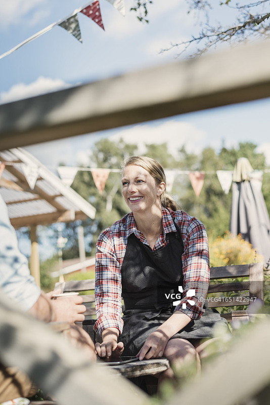 快乐的女人在花园里与同事交谈时微笑图片素材