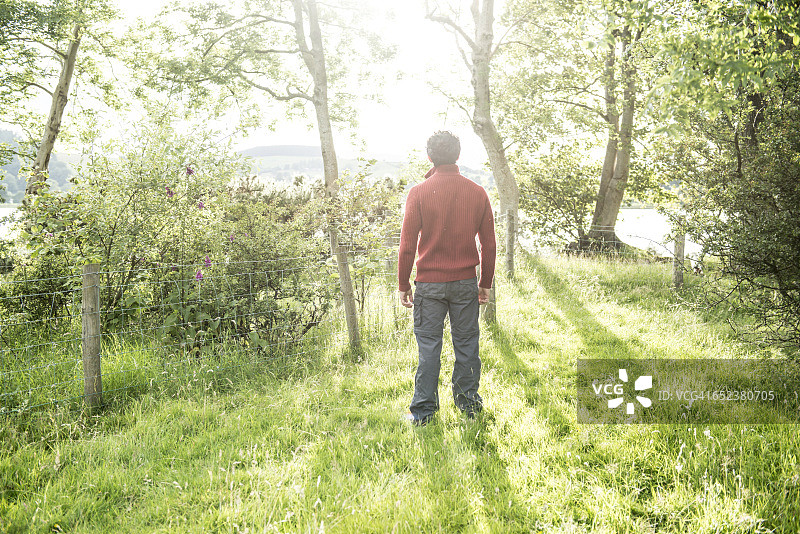 站在威尔士巴拉湖岸边的穿红色套头衫的络腮胡男人图片素材