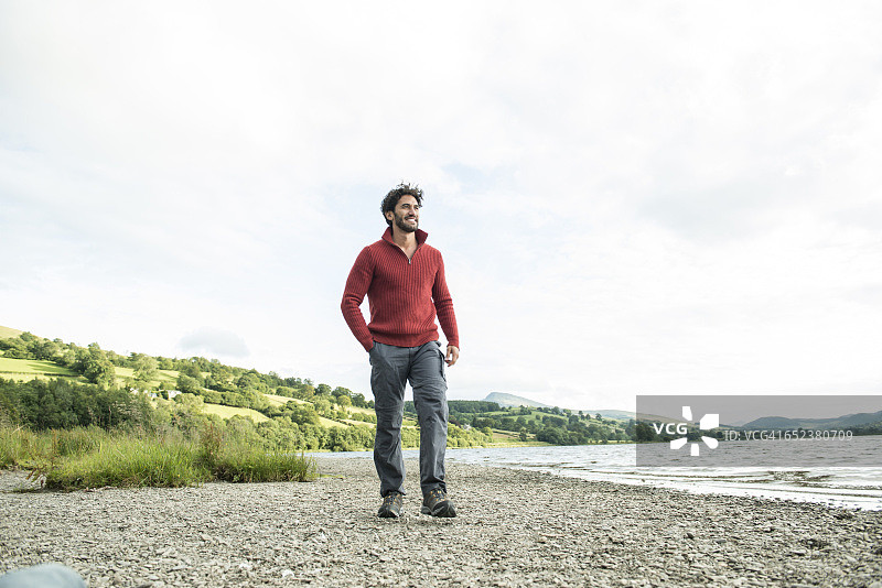 站在威尔士巴拉湖岸边的穿红色套头衫的络腮胡男人图片素材