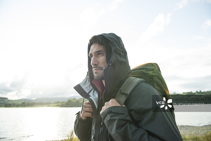 穿着登山服的络腮胡男人在威尔士巴拉湖岸边行走图片素材