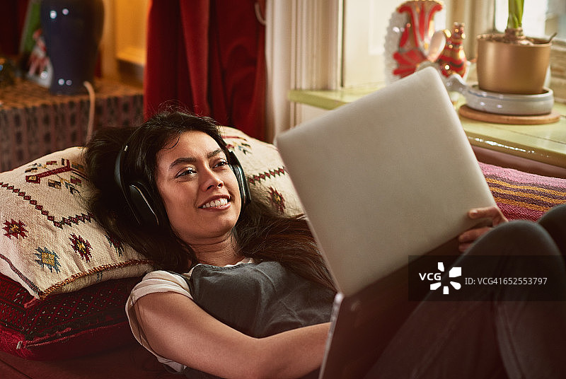 年轻女人在笔记本电脑上看电影图片素材