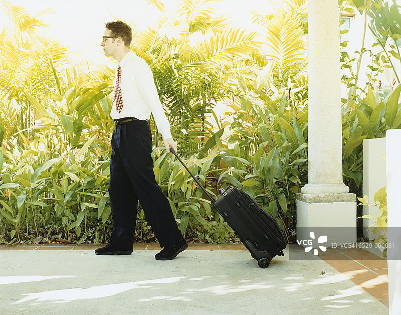 男人带着行李离开酒店图片素材