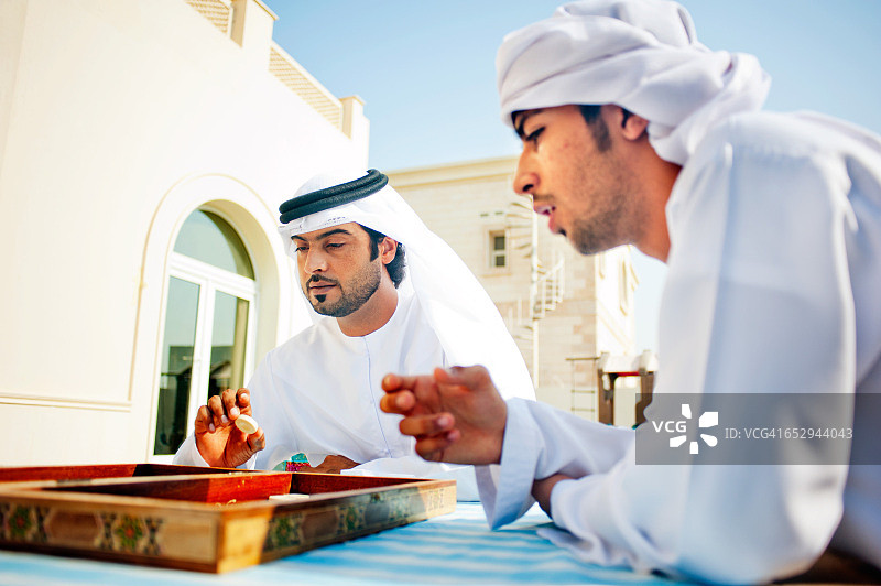 一个阿联酋家庭在花园里玩双陆棋图片素材