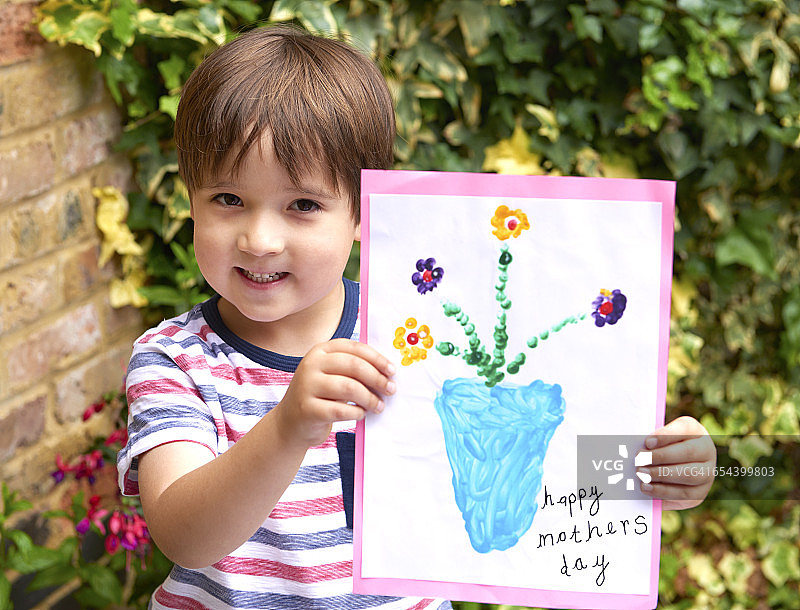 拿着母亲节贺卡的四岁儿童图片素材
