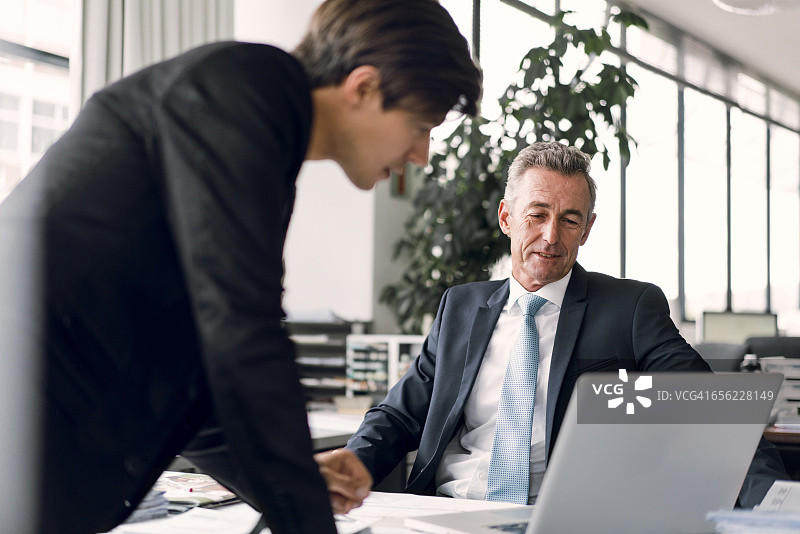 男同事在办公室使用笔记本电脑图片素材