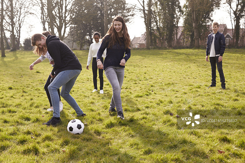 青少年在公园里踢足球图片素材