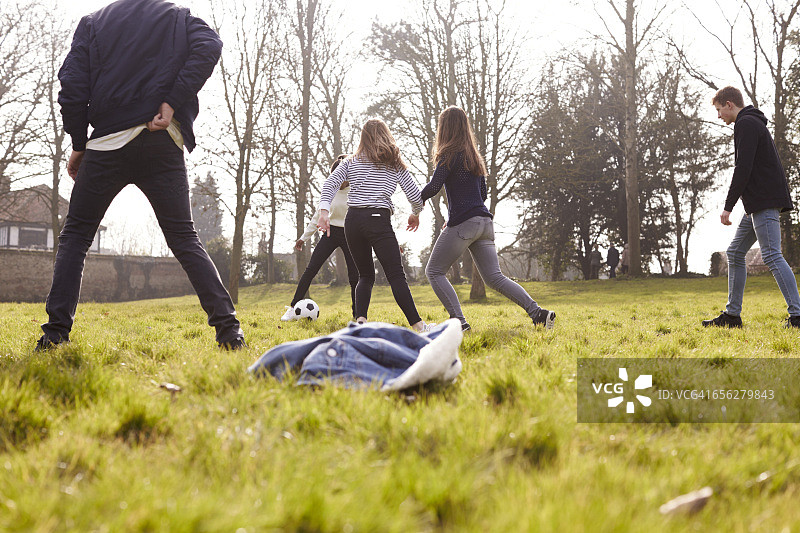 青少年在公园里踢足球图片素材
