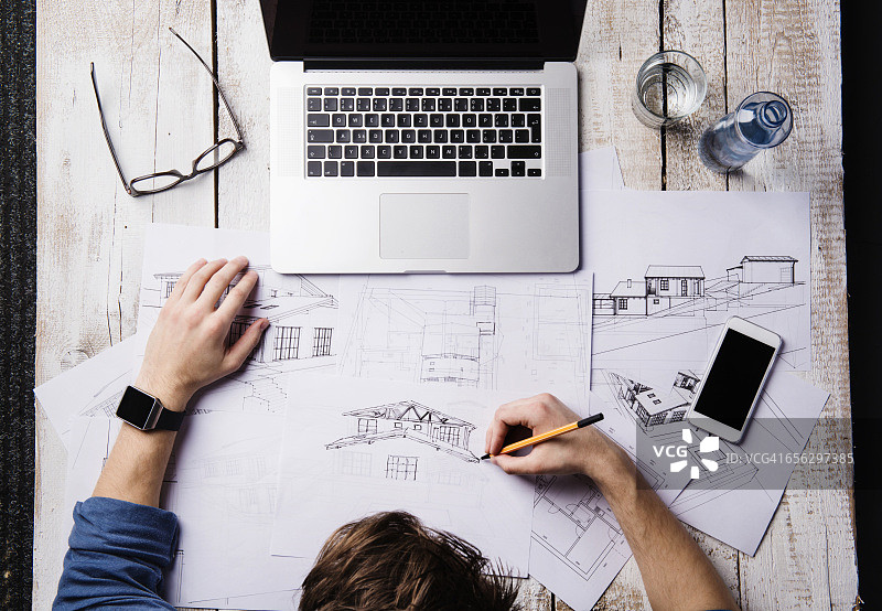 建筑师在办公桌前用笔记本电脑绘制草图图片素材