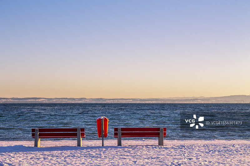 瑞士阿尔邦：康斯坦茨湖暮光下的红色长椅和垃圾箱图片素材