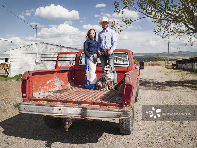 在皮卡车里与狗一起的牛仔女郎和牛仔图片素材