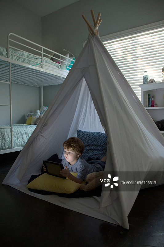 平板电脑屏幕照亮了男孩的脸图片素材