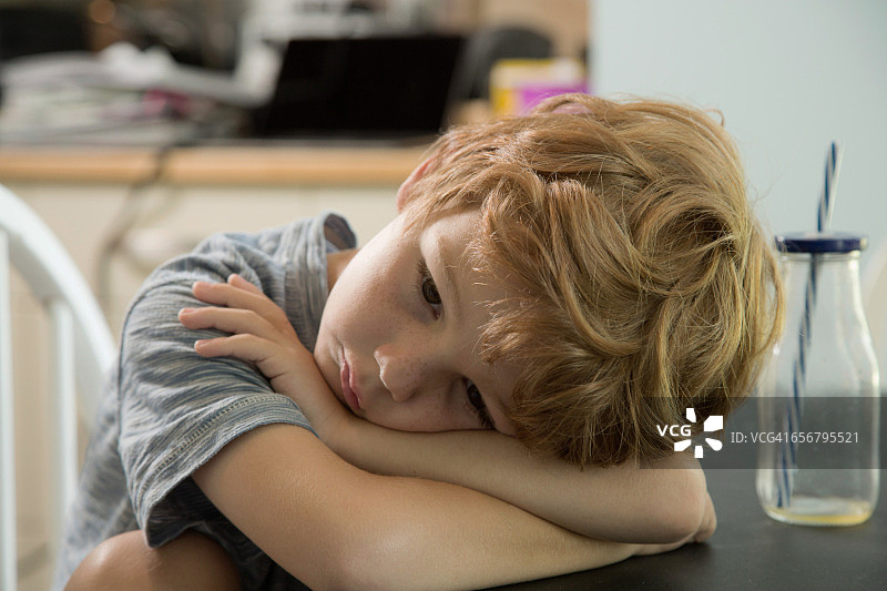 小男孩双手托腮，看起来很悲伤图片素材