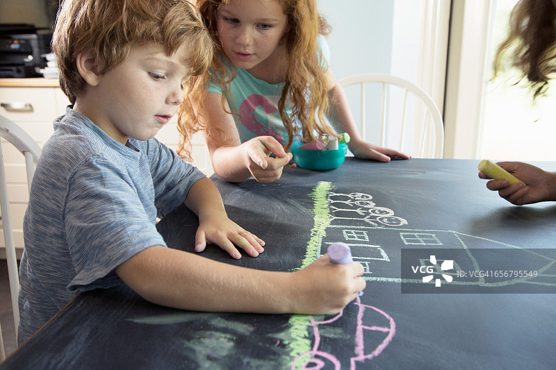 孩子们在黑板上画快乐的场景图片素材