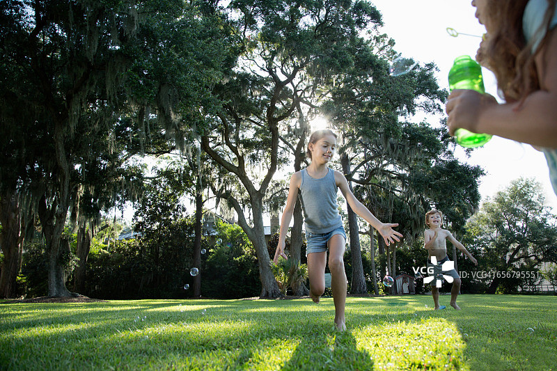 孩子们在户外追逐泡泡图片素材