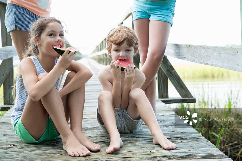一群年轻的孩子在户外吃西瓜图片素材