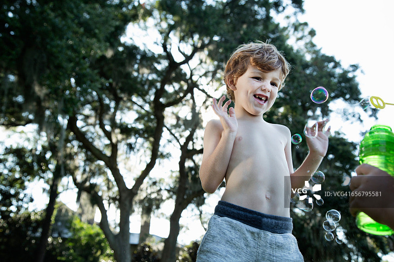 在户外吹泡泡的男孩图片素材