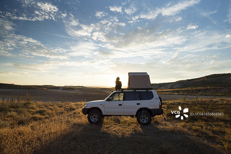 女人在带有帐篷的车辆顶部向外看图片素材
