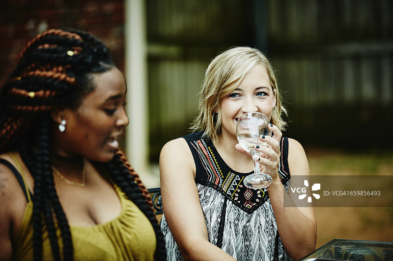 微笑的女人与朋友分享葡萄酒图片素材