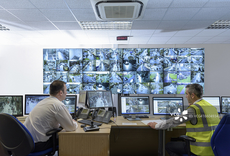 带有视频墙的保安控制室里的保安图片素材