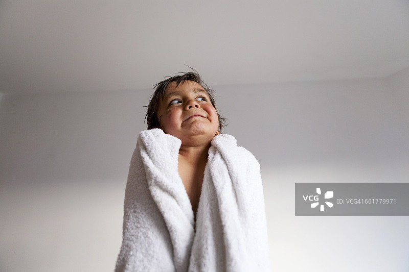 洗完澡后，裹着浴巾做鬼脸的小男孩肖像图片素材