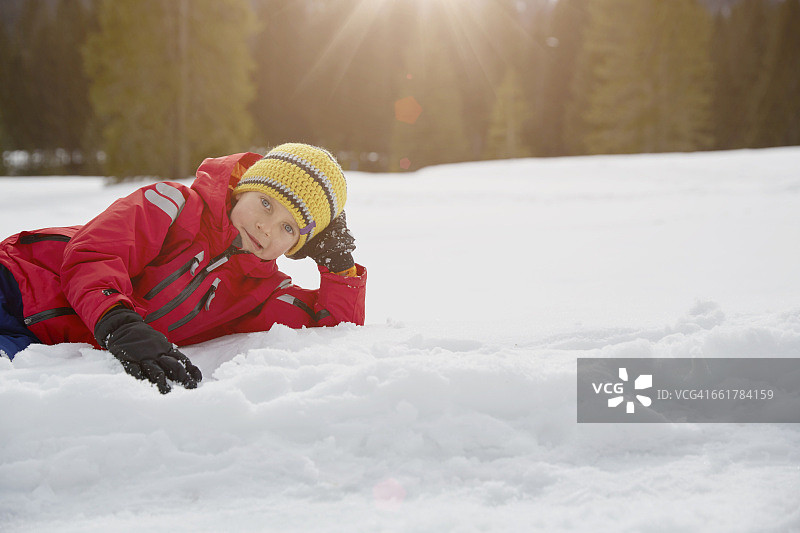 男孩躺在雪地上的肖像，阿尔毛，巴伐利亚，德国图片素材