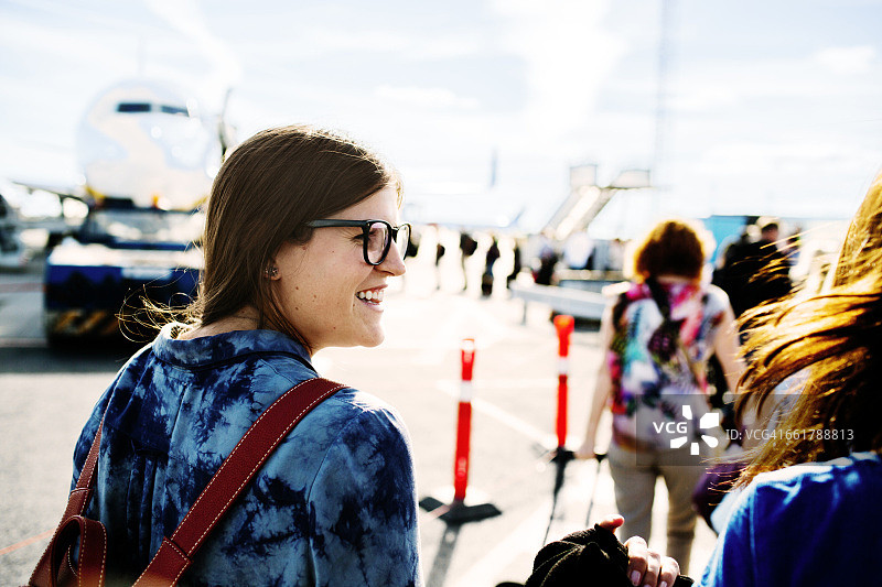 快乐的女商人走向航站楼的飞机图片素材
