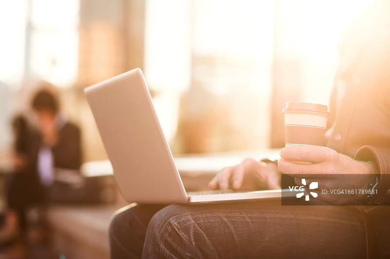 商人于火车站外使用笔记本电脑图片素材