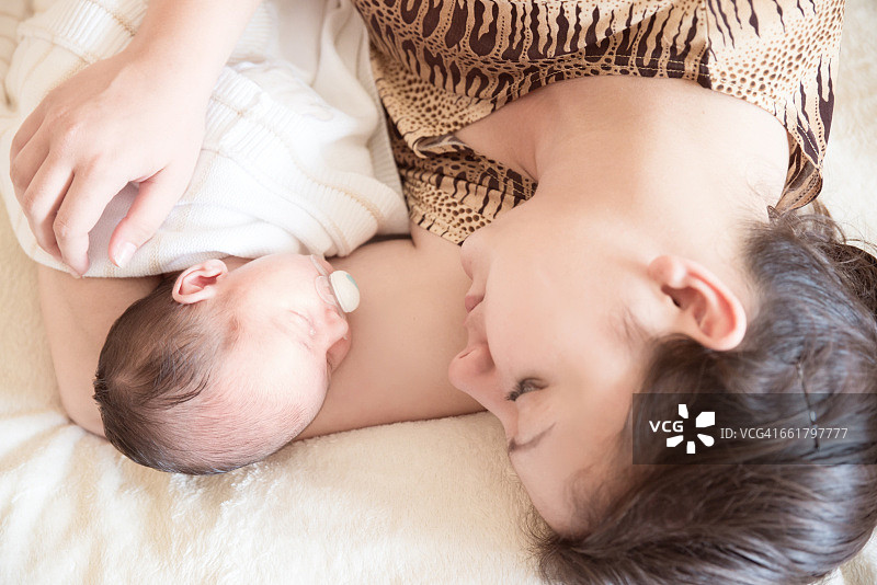母亲和新生男婴躺在床上图片素材