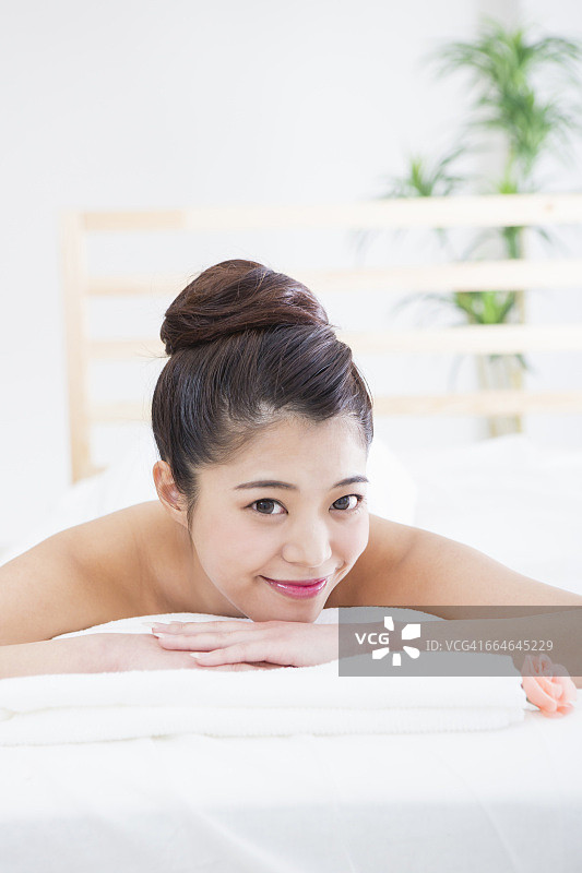 日本女人躺在床上接受美容护理图片素材