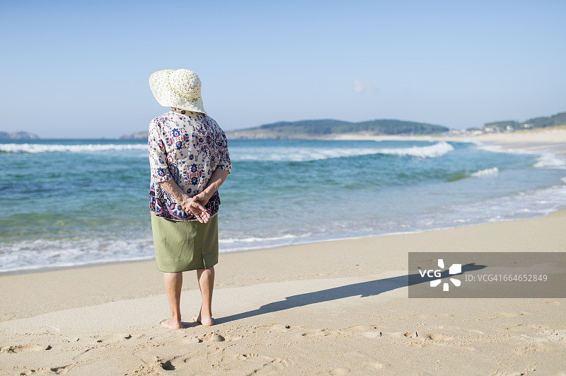 站在海滩上的老年妇女的背影图片素材