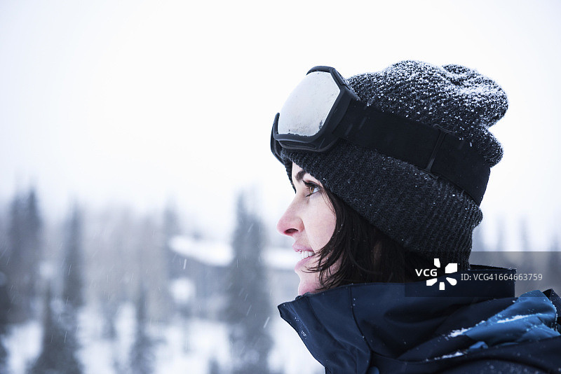 戴滑雪镜凝视雪景的年轻女子肖像，美国犹他州盐湖城布莱顿滑雪场外图片素材