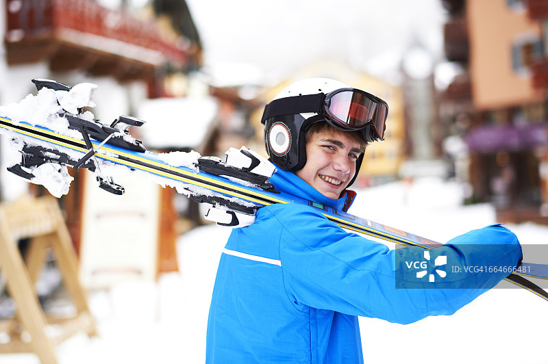 肩上扛着滑雪板的青少年男孩的肖像图片素材