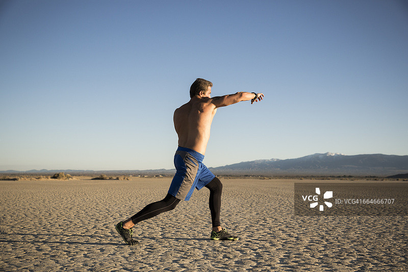 男人在加利福尼亚州埃尔米拉奇干涸的湖床上进行跆拳道训练图片素材