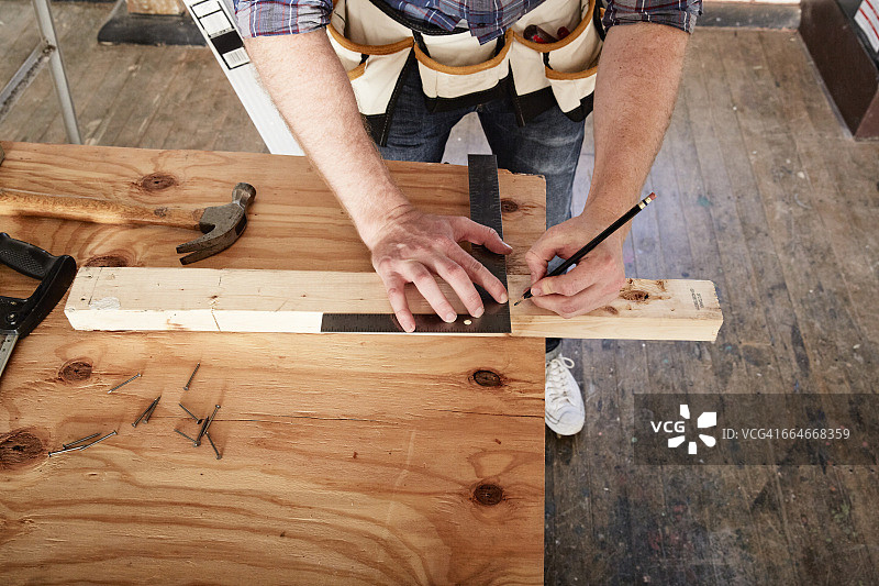 木匠使用方尺标记木材的局部视图图片素材