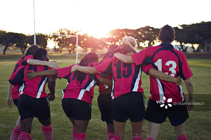 女子橄榄球队日落时分并肩前行图片素材