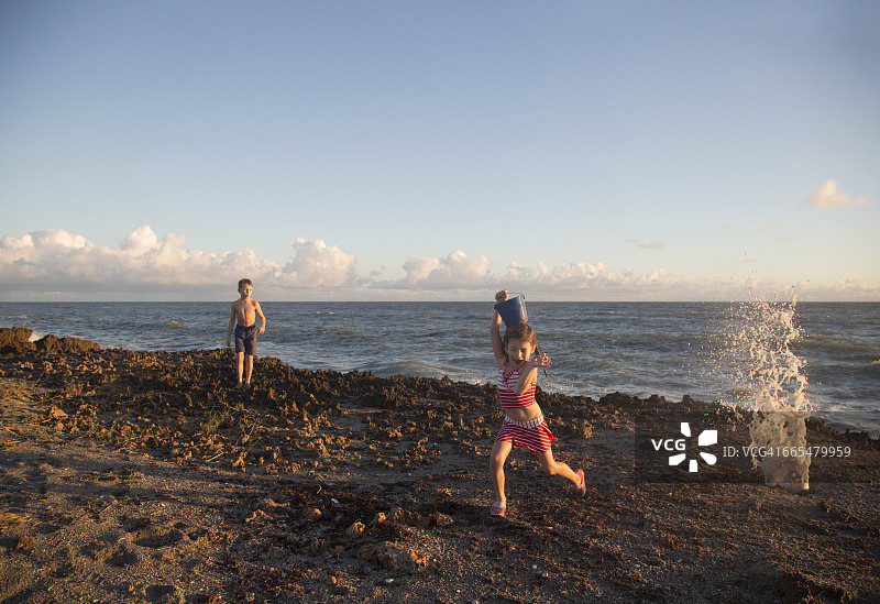 在美国佛罗里达海滩躲避海浪的女孩图片素材