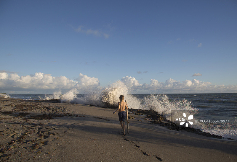 男孩在佛罗里达州朱庇特岛的吹石保护区探索海滩的背影图片素材